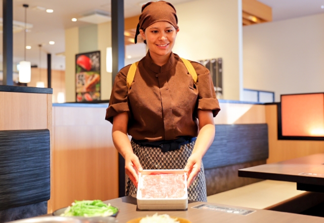 笑顔で料理を提供する外国人スタッフのSさん