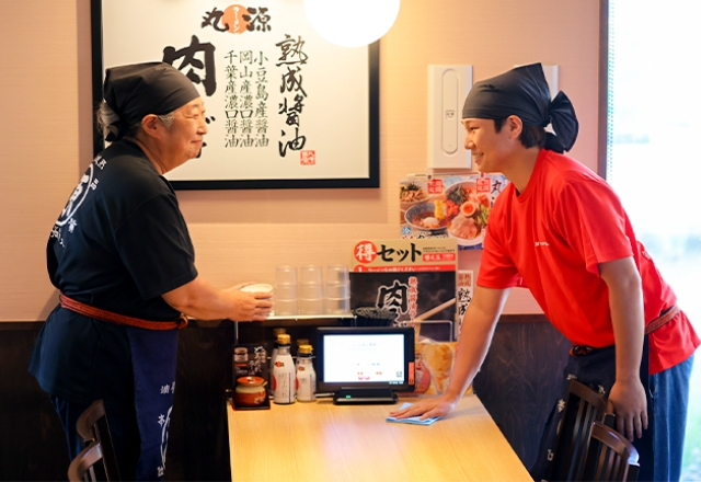 他の従業員と笑顔でやり取りをするシニアのT.H.さん