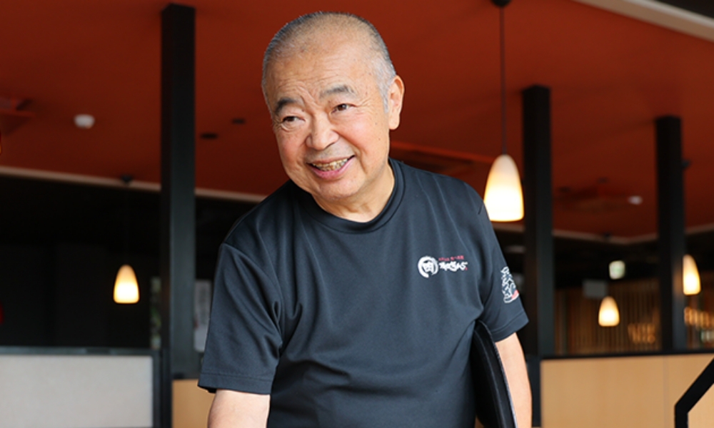 笑顔でテーブル席で接客をするシニア