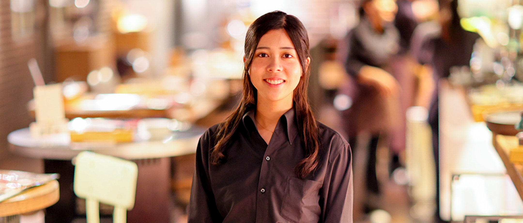 お店の店内で笑顔を向けている学生のH.S.さん